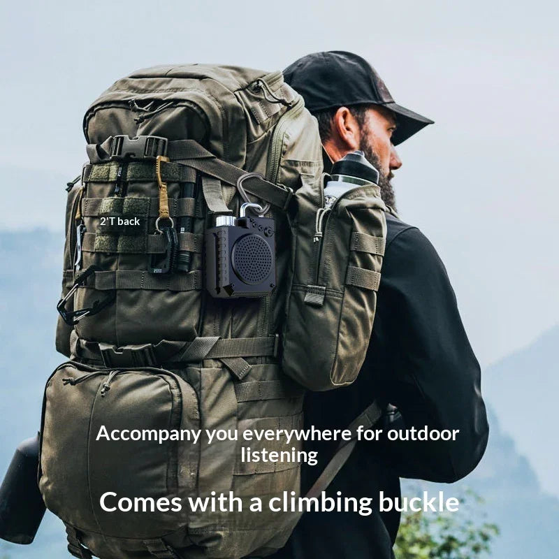 Man hiking with a large green backpack, portable speaker attached with climbing buckle outdoors